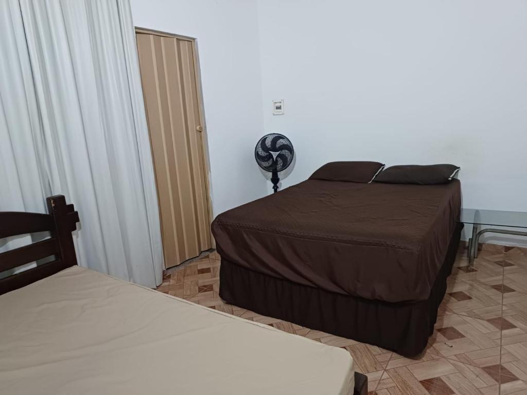 - une chambre avec 2 lits et un bureau avec un ventilateur dans l'établissement Casa Lagoa Terraço, à Araruama