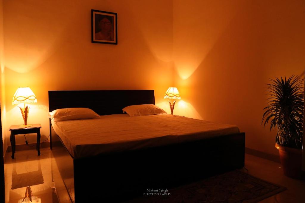 1 dormitorio con 1 cama grande y 2 lámparas en Tattva Luxurious Apartment, en Varanasi