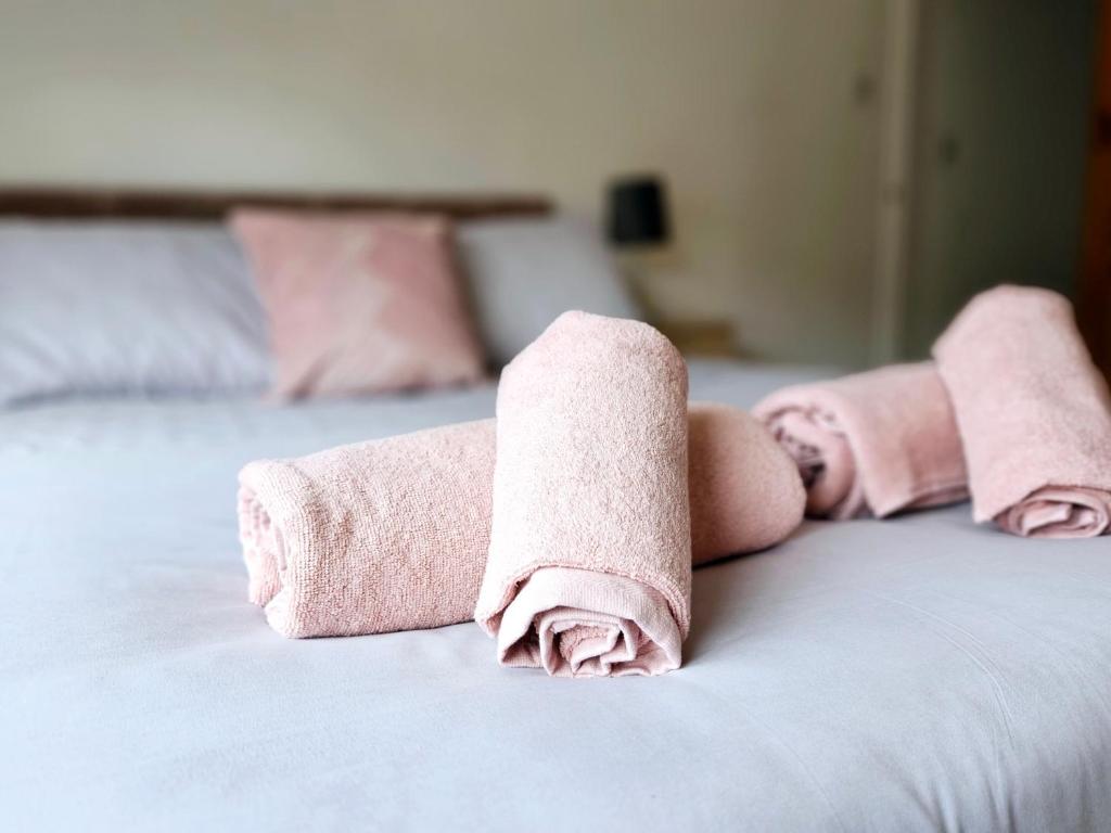 2 asciugamani arrotolati sopra un letto di Comfortable 2 Bed House Near City Centre and M1 a Leicester