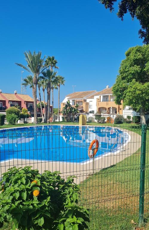 una piscina con una valla alrededor en Apto Aldea del Coto, en Chiclana de la Frontera