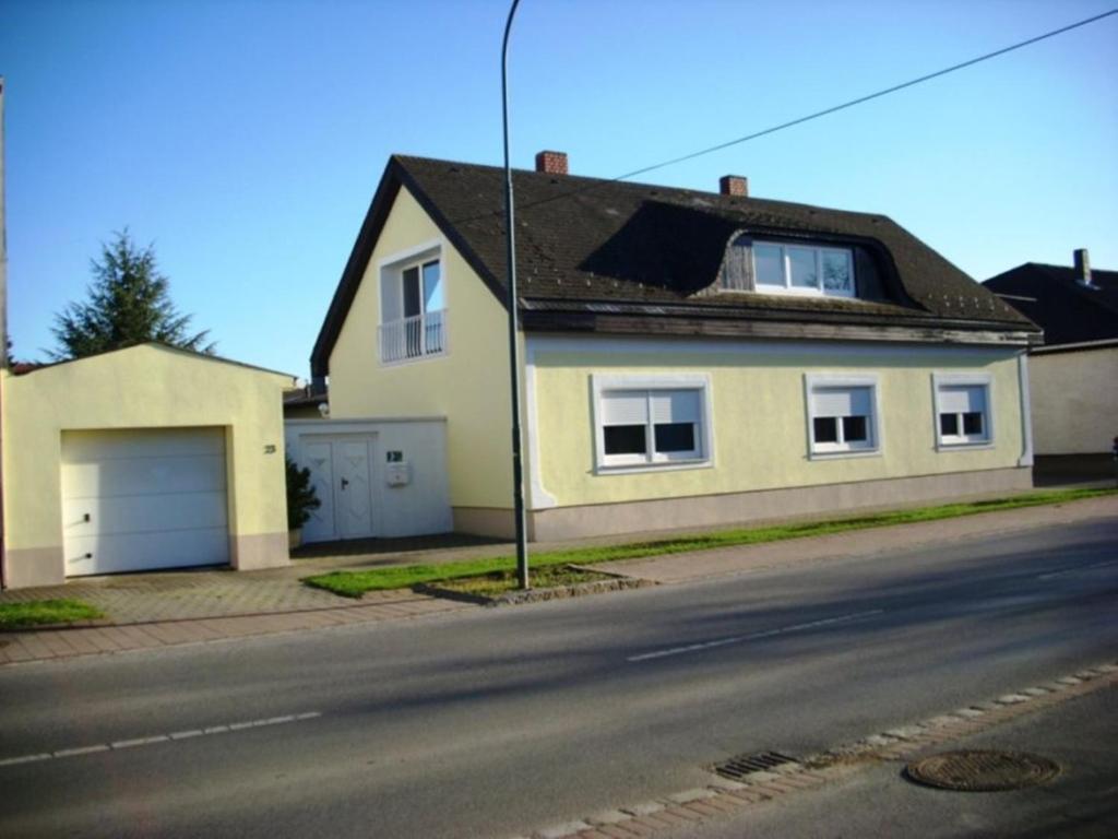 a white house with a garage on a street at Gästehaus Josef Lang in Andau