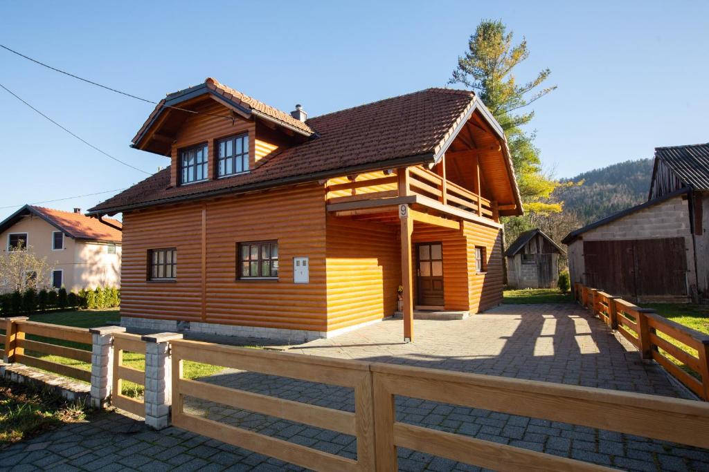una casa de madera con una valla delante en Holiday house with a parking space Jasenak, Karlovac - 20579, en Jasenak