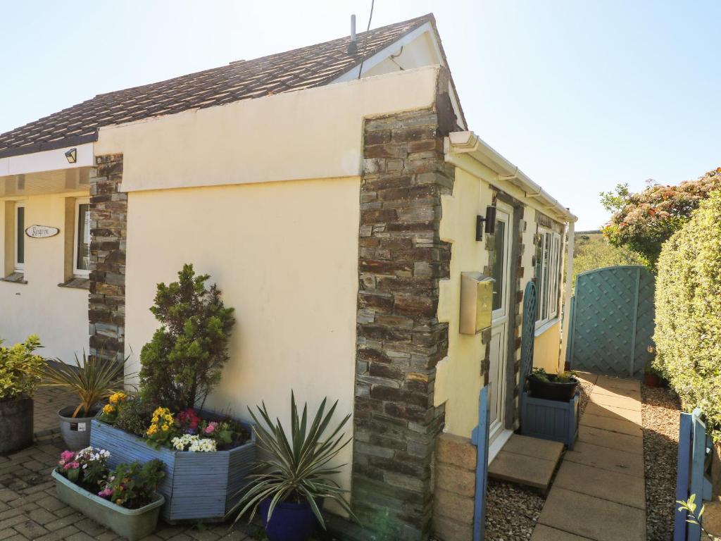 a house with flowers in pots on the side of it at Respryn in Mevagissey