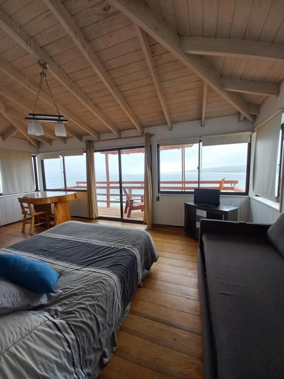 1 Schlafzimmer mit 2 Betten, einem Tisch und Stühlen in der Unterkunft Pingüino en la roca - Concón in Concón