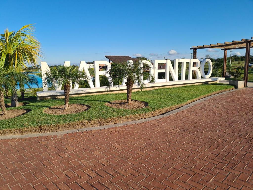ein Schild für den Zugang zu einem Resort mit Palmen in der Unterkunft BEACH HOUSE Mar Adentro, lugar paradisiaco in Santa Cruz de la Sierra