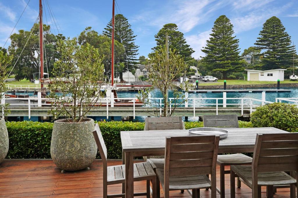 a wooden table and chairs with a view of a marina at Steam Packet Wharf in Port Fairy