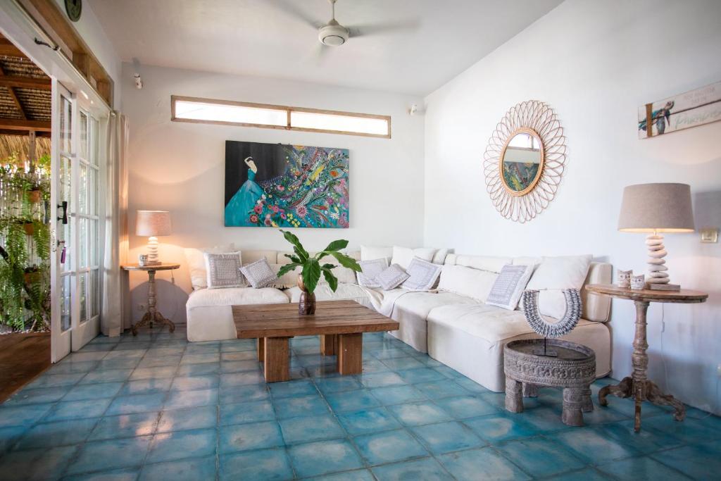 a living room with a white couch and a table at Serenity Luxurious Beachfront Villa & Spa with private Infinity Pool, 8 Guests in Gili Air