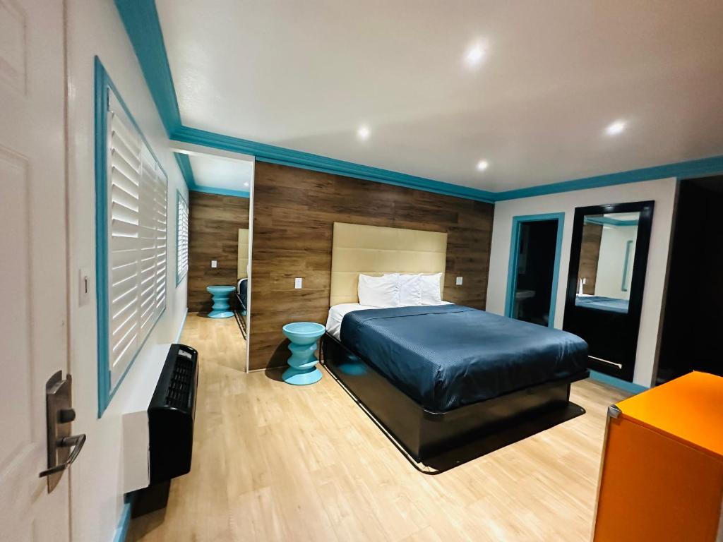 1 dormitorio con 1 cama grande y espejo en Casa Blanca Inn & Suites Whittier, en Whittier
