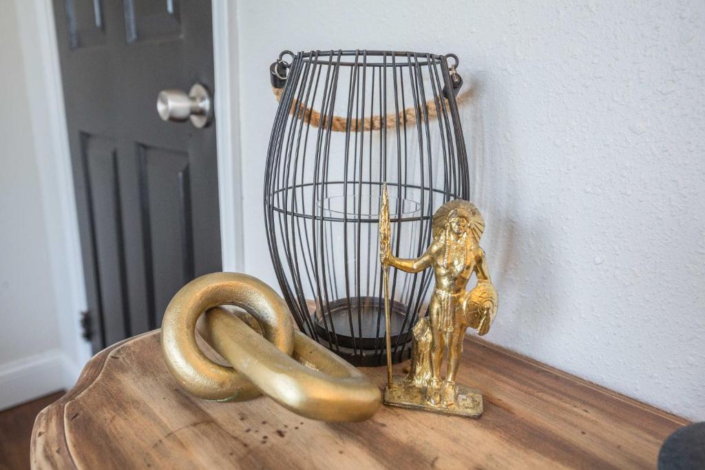 a gold statue next to a cage and a pretzel at Casa Cima in Dallas