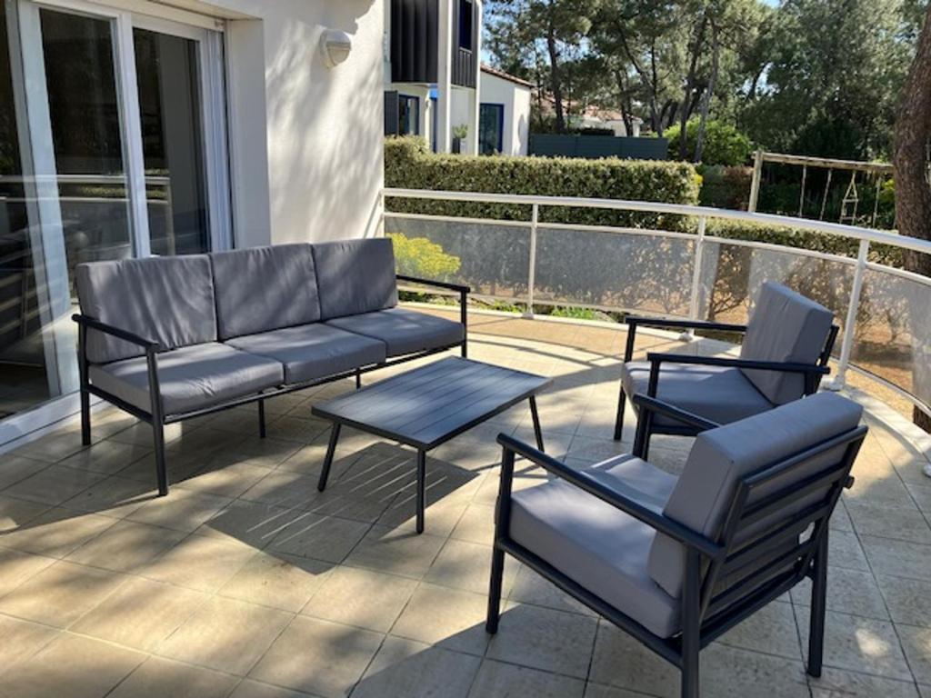 2 chaises et un canapé sur la terrasse dans l'établissement Villa Proche Plage avec Jardin, Terrasse et WiFi – La Tranche-sur-Mer - FR-1-22-272, à La Tranche-sur-Mer