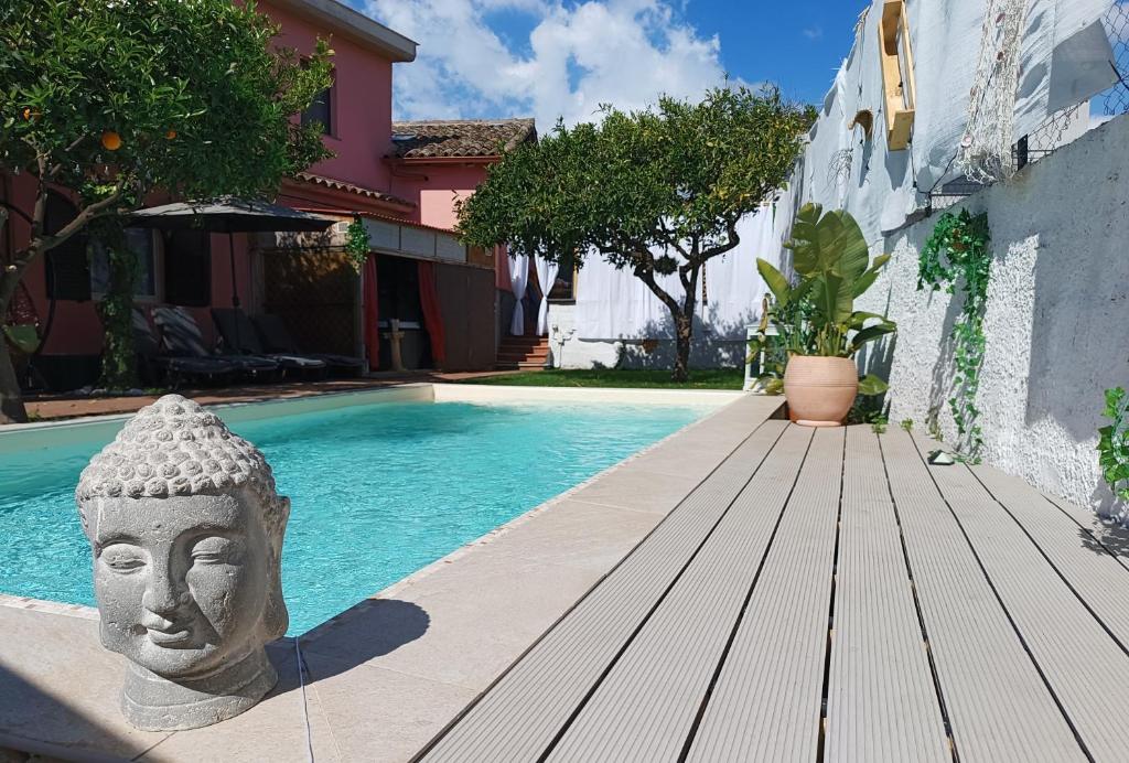 ein Schwimmbad mit einer Statue neben einem Haus in der Unterkunft Casa Vacanze Noemi in Riposto