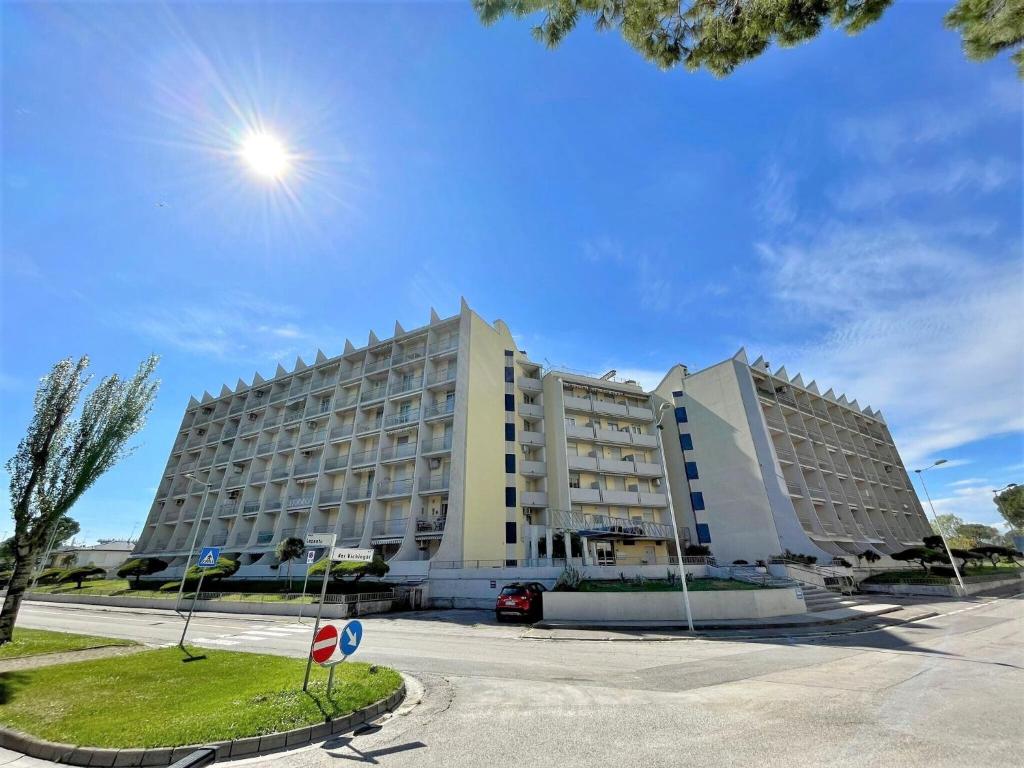 ein großes weißes Gebäude mit einer Straße davor in der Unterkunft Charming holiday home in Porto Santa Margherita with terrace in Porto Santa Margherita