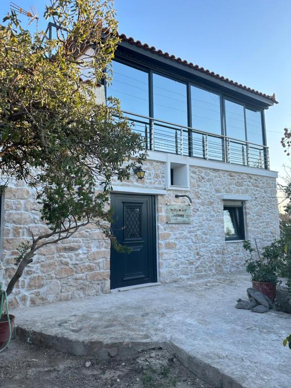 a house with a black door and a balcony at SolMar Aegina with private pool - jacuzzi in Khlóï