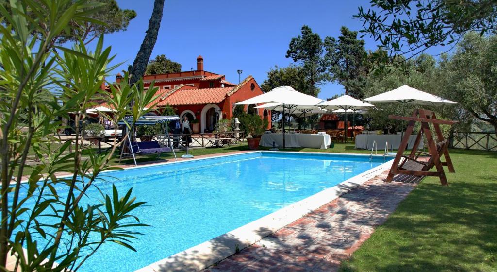 una piscina frente a una casa con sombrillas en Parco delle Nazioni - Relax Grand Resort en Castel di Decima