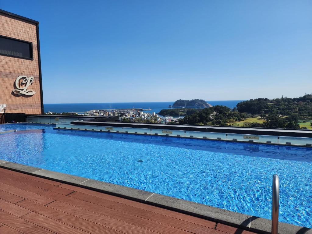 una gran piscina al lado de un edificio en Casaloma Hotel en Seogwipo