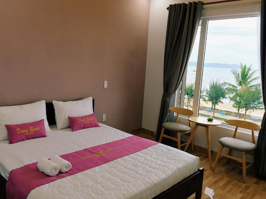 a bedroom with a bed with a view of the ocean at DANA BEACH Motel in Da Nang