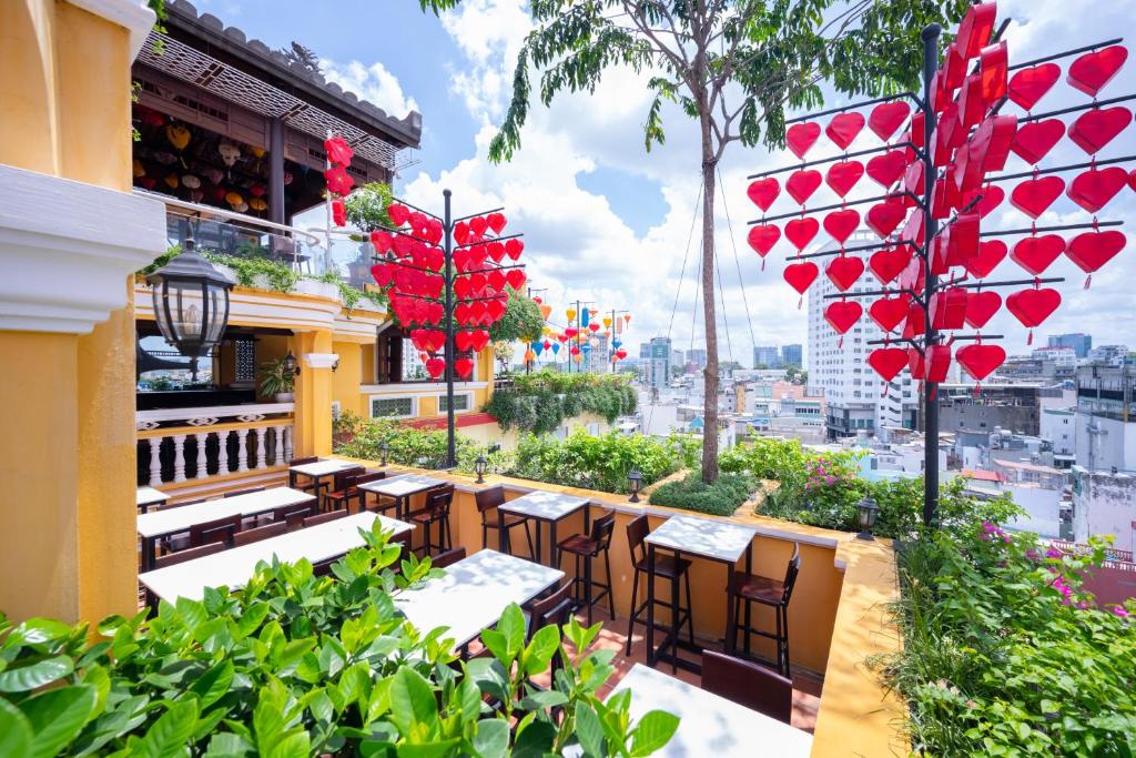 a restaurant with tables and chairs on a balcony at Duc Vuong Saigon Hotel - Bui Vien in Ho Chi Minh City