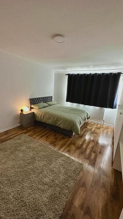 a bedroom with a bed with a window and a rug at Cozy home in a peaceful area in Hayes