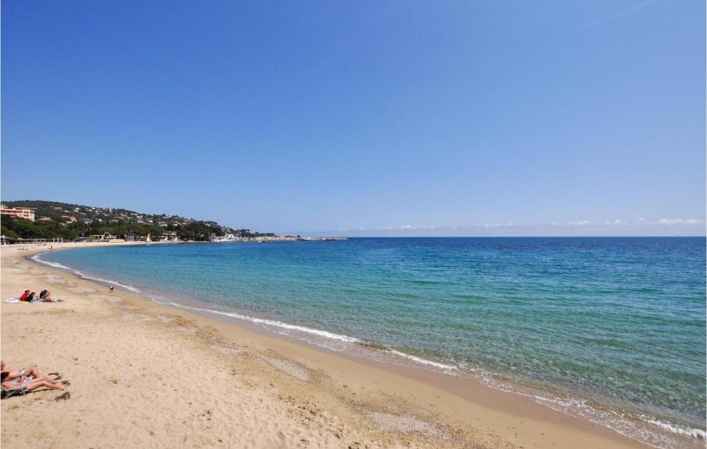 a beach with people laying on the sand and the water at Amazing Apartment In Sainte-Maxime in Sainte-Maxime