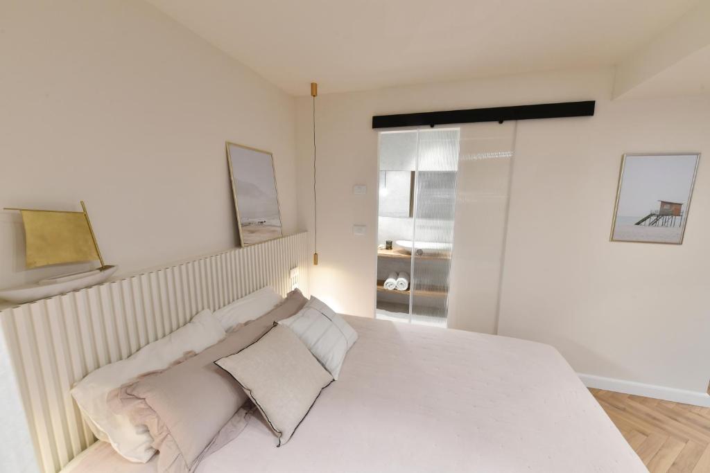a white bedroom with a bed with white pillows at צימר רפאל in Eilat