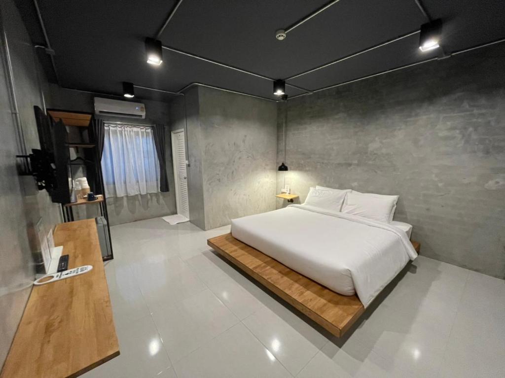 a bedroom with a large white bed in a room at Loft Space Hotel in Ranong