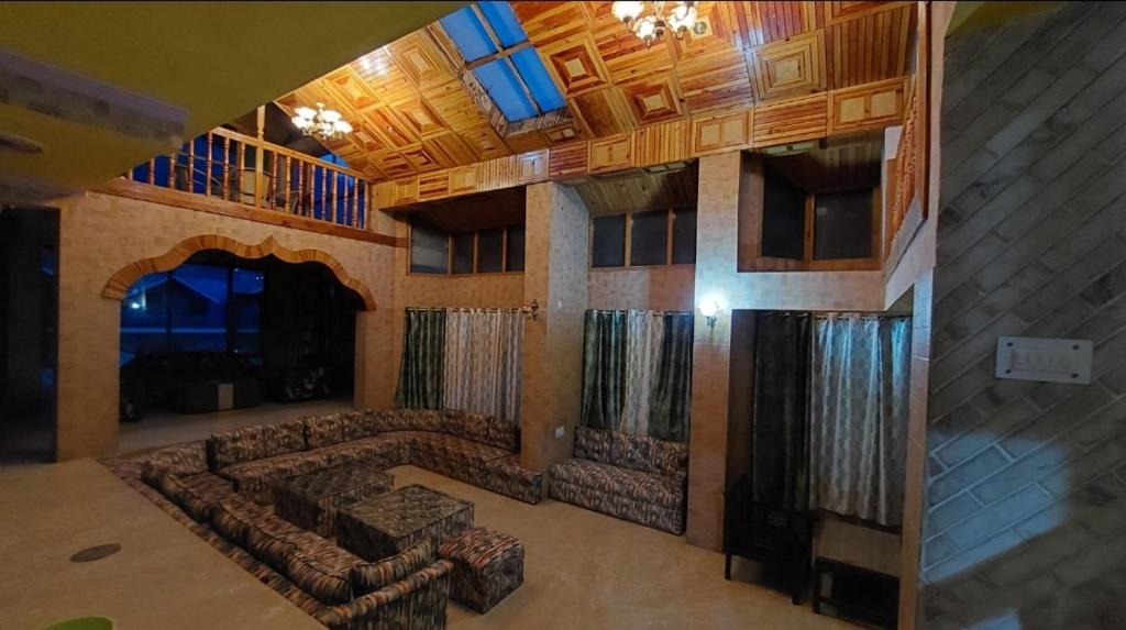 un ampio soggiorno con divani in un edificio di Hotel Jubilant Manali a Manāli