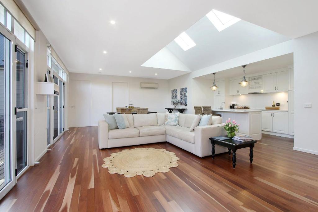 een woonkamer met een witte bank en een keuken bij Next to Bliss Luxury Guesthouse in Bright