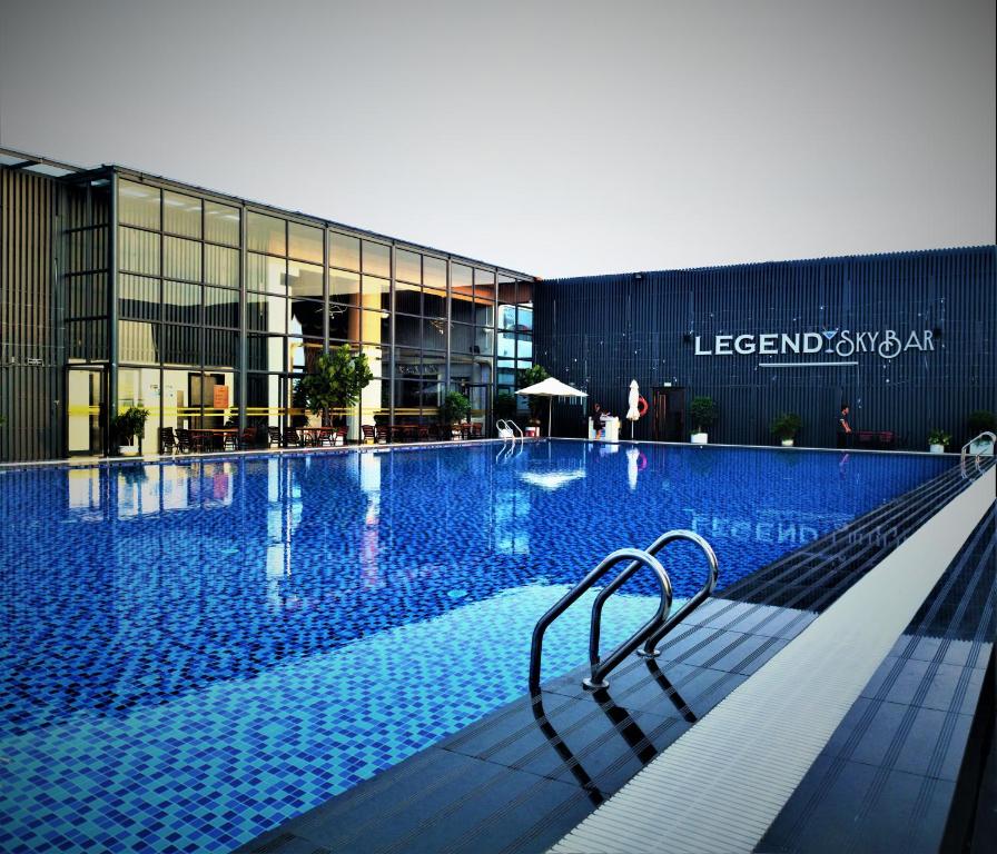 uma piscina com um banco em frente a um edifício em Legend Hotel and Resort em Sihanoukville