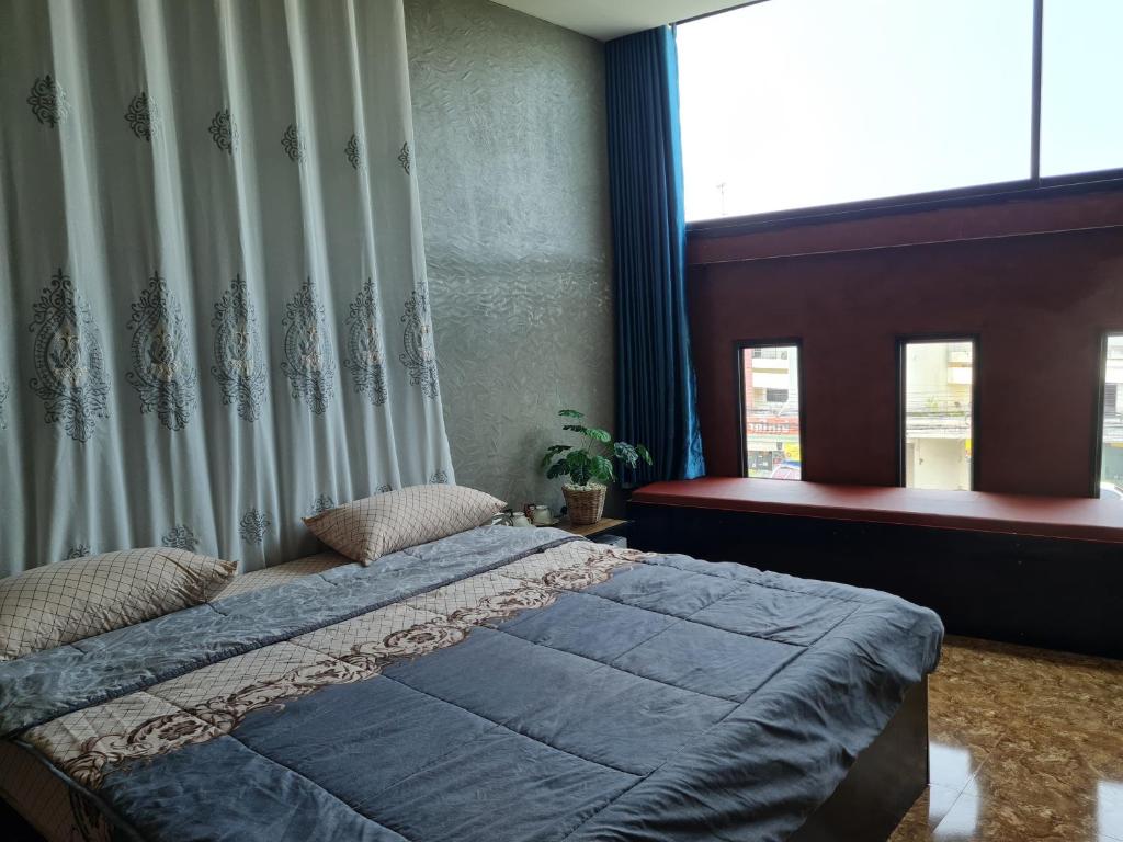 Un dormitorio con una cama grande y una ventana en The Greenergy - NO ELEVATOR en Hat Yai