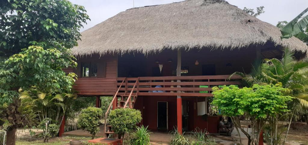 a house with a thatched roof and a porch at Fandee Island - Secret Private House - Tad Lo Bolaven Loop Pakse in Ban Kiangtat