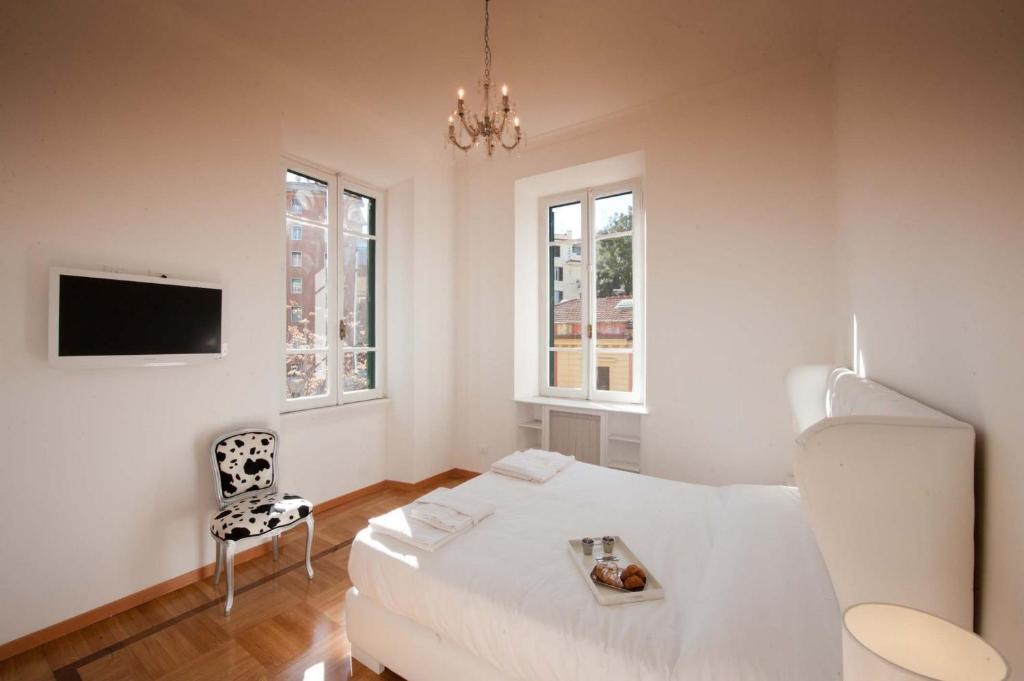 a white living room with a white couch and a chair at Imperia Suite in Rome