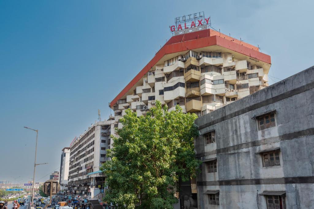 een gebouw met een bord erop bij Hotel Galaxy Opp Surat Railway Station in Surat