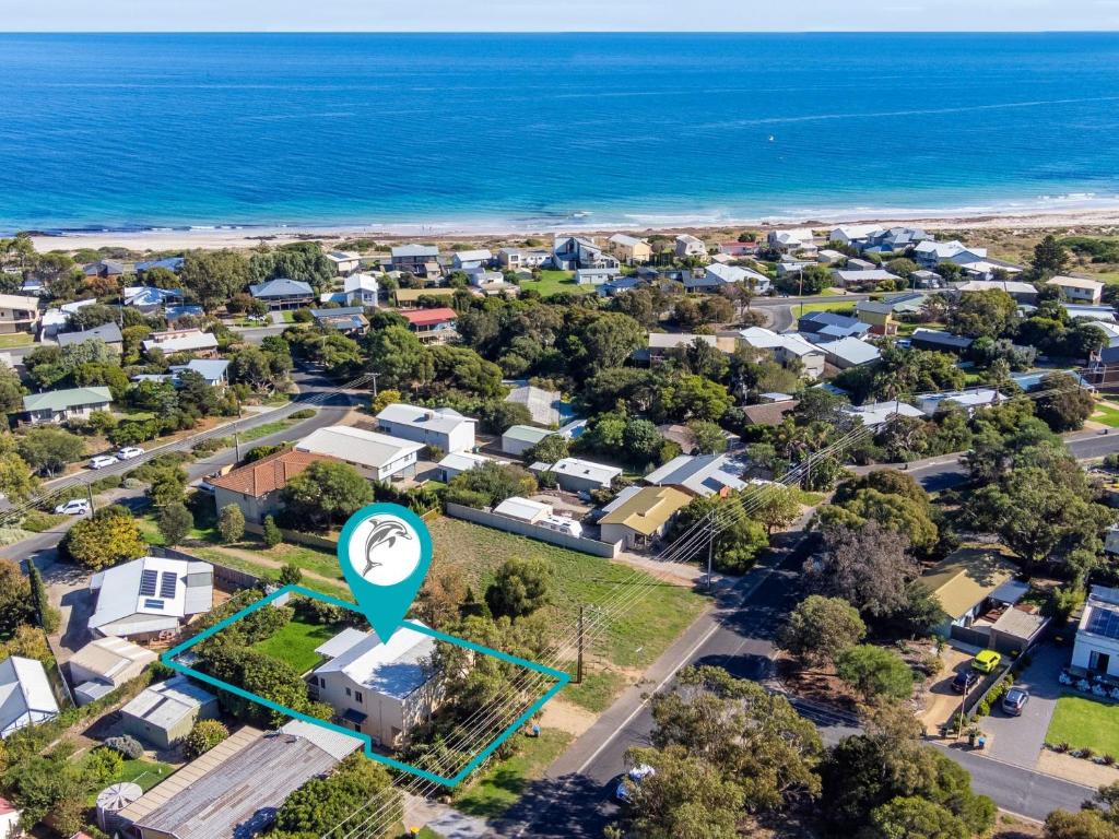 an aerial view of a suburb with a blue arrow pointing to a house at 22 Broadbeach Drive in Normanville
