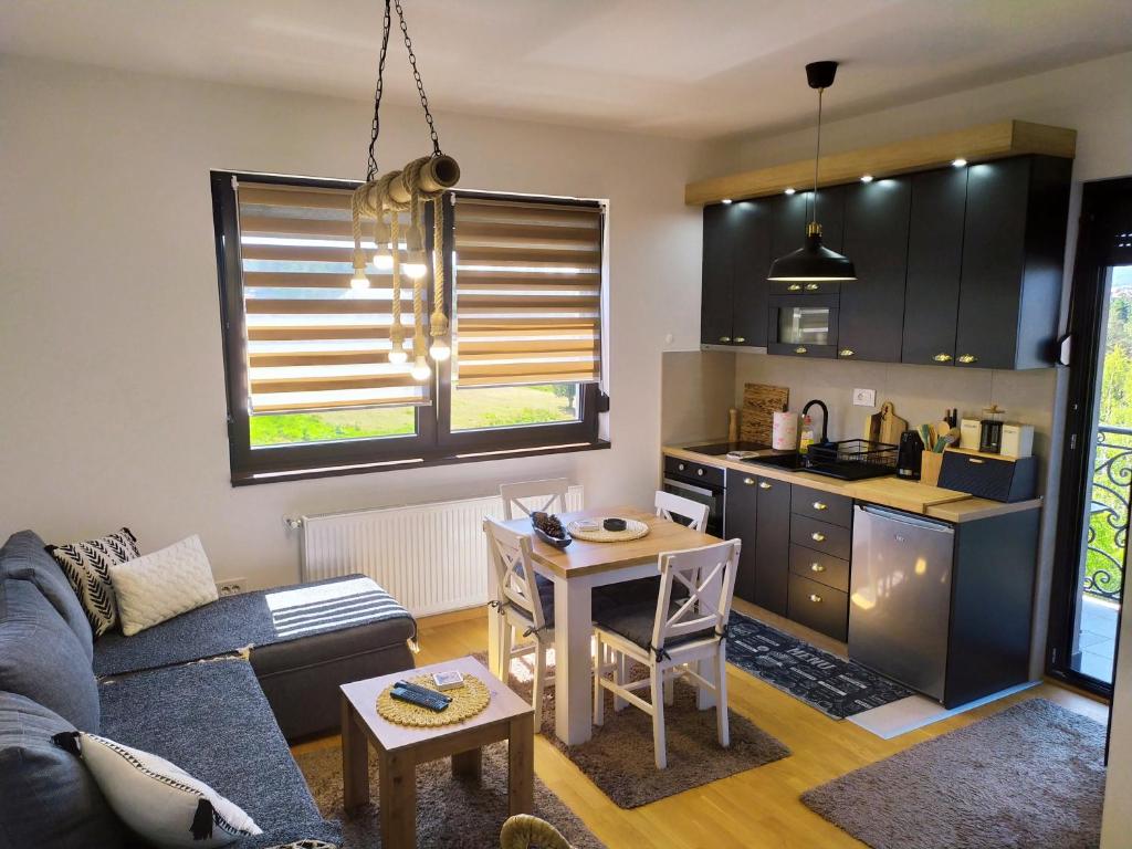 ein Wohnzimmer mit einem Sofa und einem Tisch sowie eine Küche in der Unterkunft Imperia M Zlatibor in Zlatibor