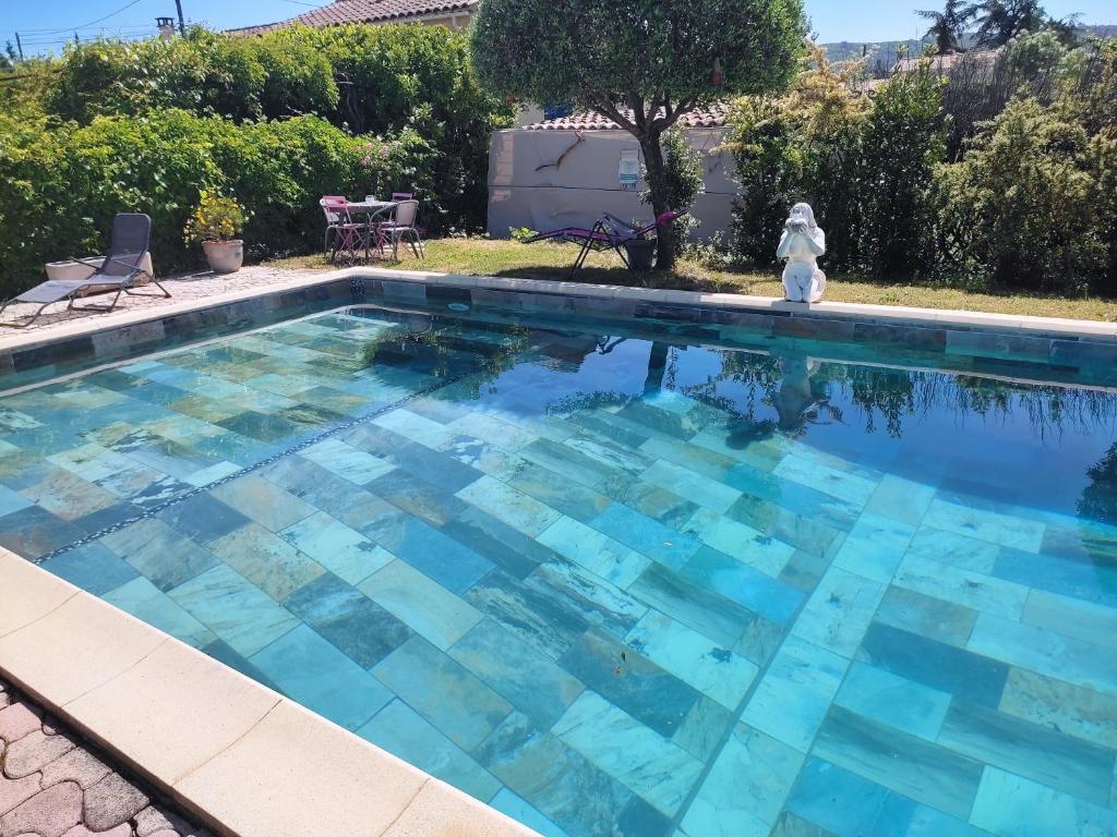 a swimming pool with blue water in a yard at Le Temps Retrouvé in Saint-Martin-de-Valgalgues