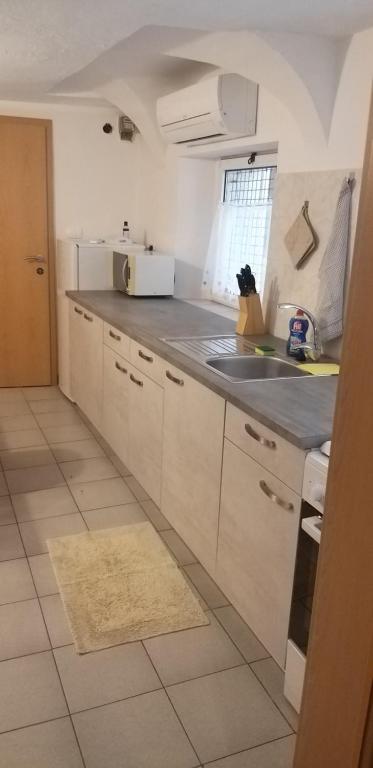 a kitchen with white cabinets and a sink and a window at Apartment Sonce in Koper