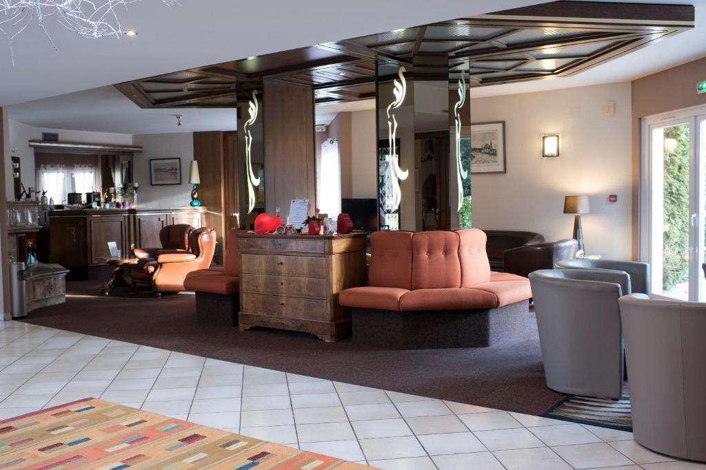 a living room with couches and a table and a room at Hotel Restaurant Le Coquelicot in Burnhaupt-le-Haut