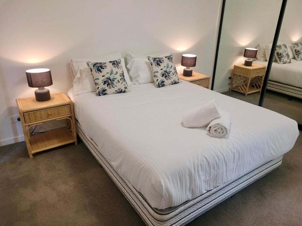 - une chambre avec un grand lit blanc et deux lampes dans l'établissement Hi Surf Unit 2, 92 Head Street, Forster, à Forster