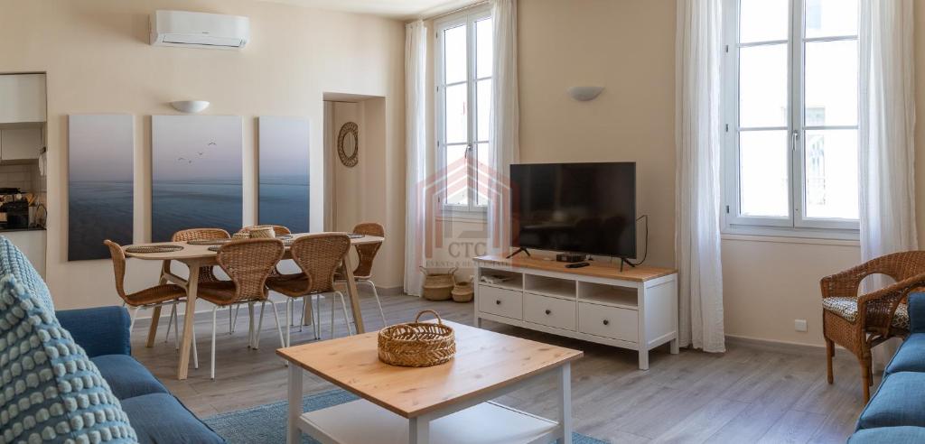 un salon avec un canapé, une télévision et une table dans l'établissement Cannes Rue d'Antibes: Agréable quatre pièces, à Cannes