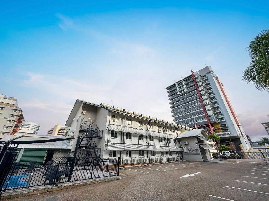 a building in a parking lot next to a tall building at DCH on Mitchell in Darwin