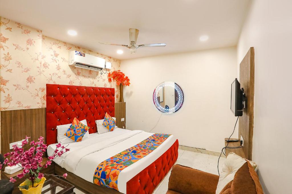 um quarto com uma cama grande e uma cabeceira vermelha em FabHotel Royal Galaxy I em Nova Deli