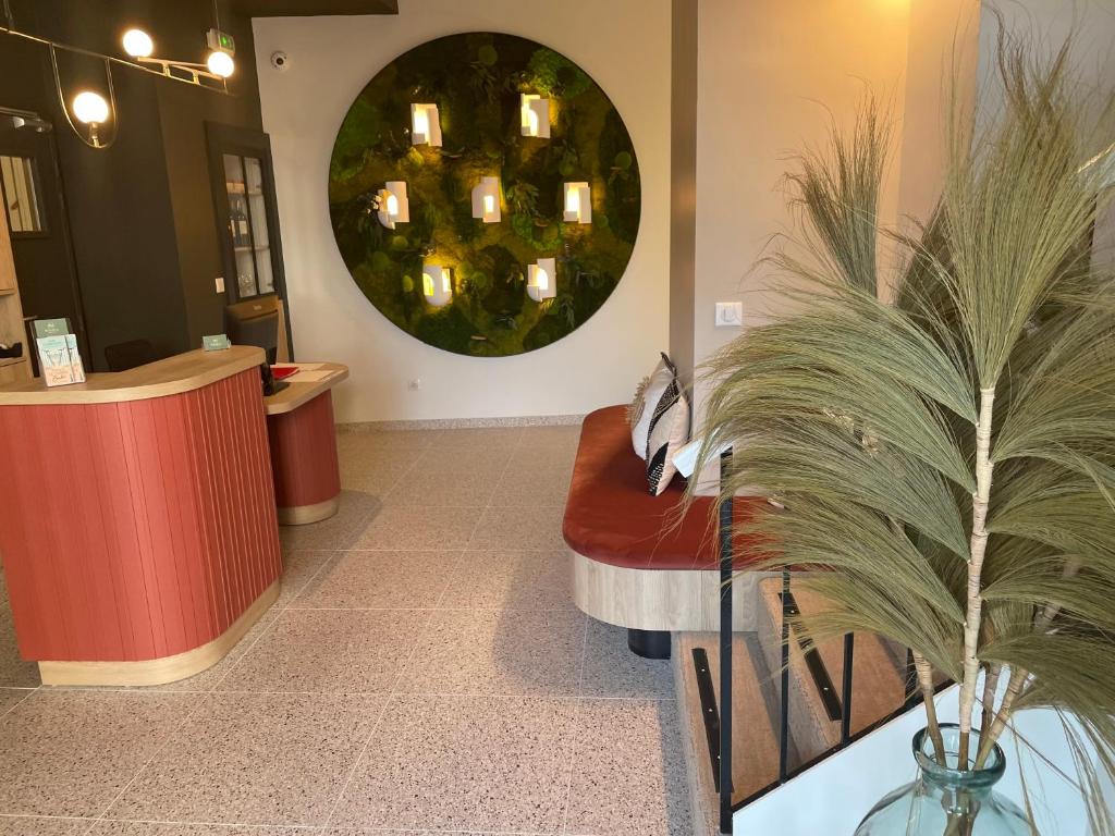 a waiting room with a red bench and a mirror at Hôtel Restaurant BO &amp; MIA in La Baule