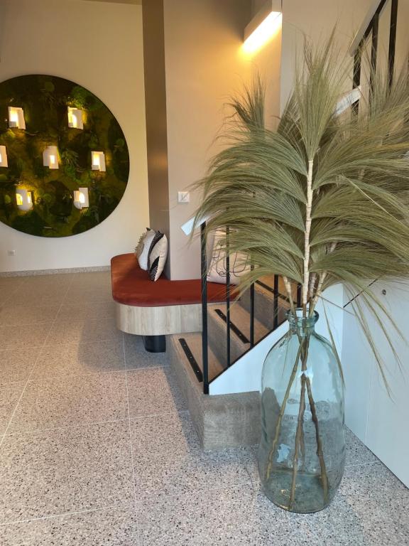 a glass vase with a plant in a room at Hôtel Restaurant BO &amp; MIA in La Baule