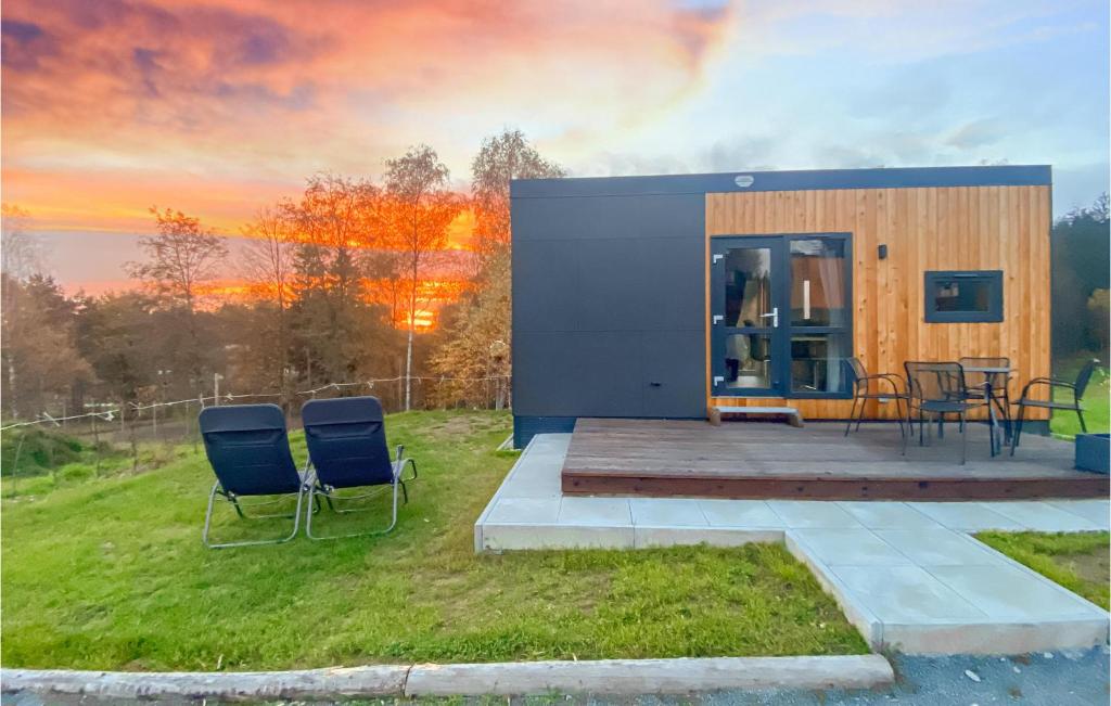 a tiny house with chairs and a sunset in the background at Blumenwiesenweg 26 in Untergriesbach