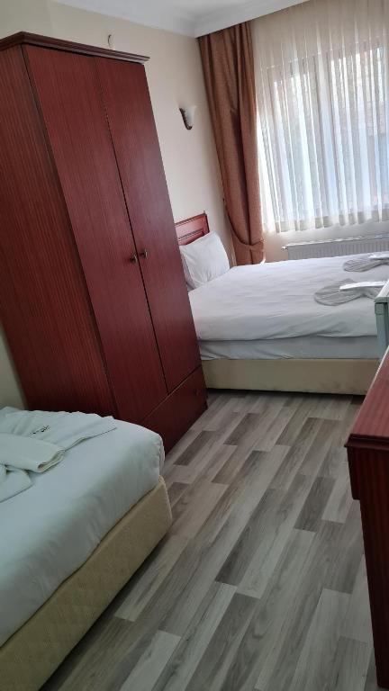 a hotel room with two beds and a cabinet at EMOS HOTEL in Istanbul