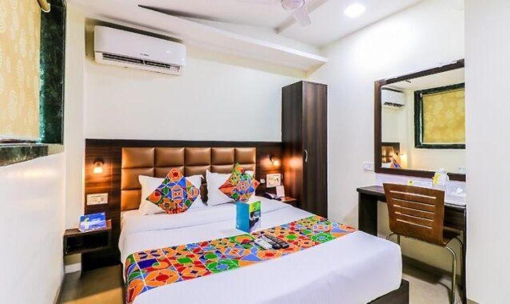 a bedroom with a bed and a desk in it at FabHotel Galaxy Suite in Mumbai