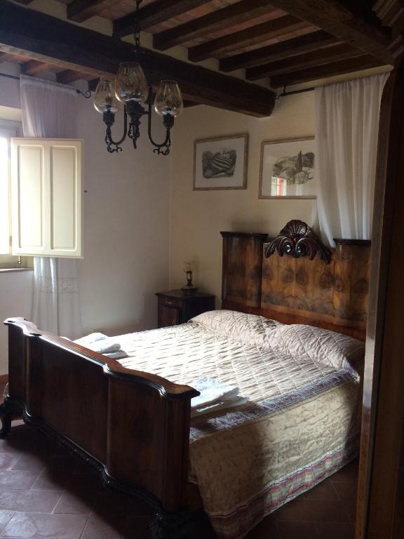 sypialnia z dużym drewnianym łóżkiem w pokoju w obiekcie San Martin del Colle Holiday Home w mieście Casciana Terme