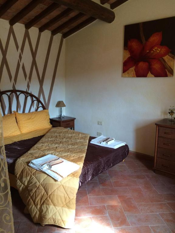 sypialnia z łóżkiem i obrazem na ścianie w obiekcie San Martin del Colle Holiday Home w mieście Casciana Terme