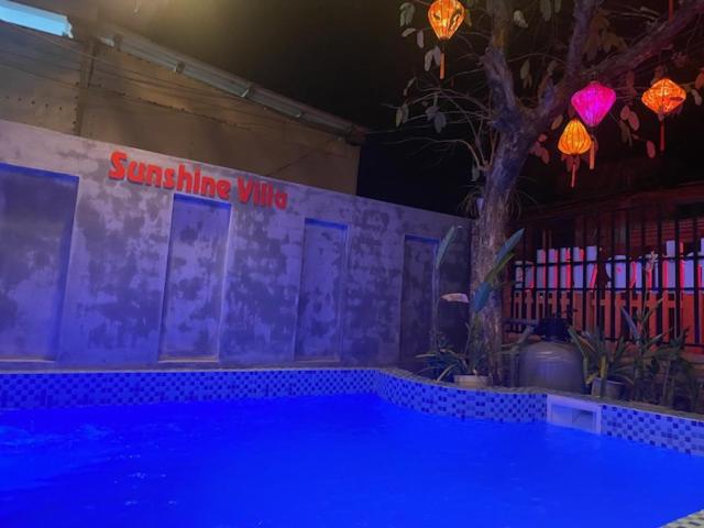 una piscina in una stanza con un albero e luci di Sunshine villa thuan an a Hue