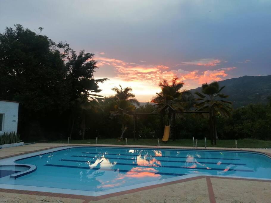 a large swimming pool with a sunset in the background at hermosa casa nueva in Copacabana